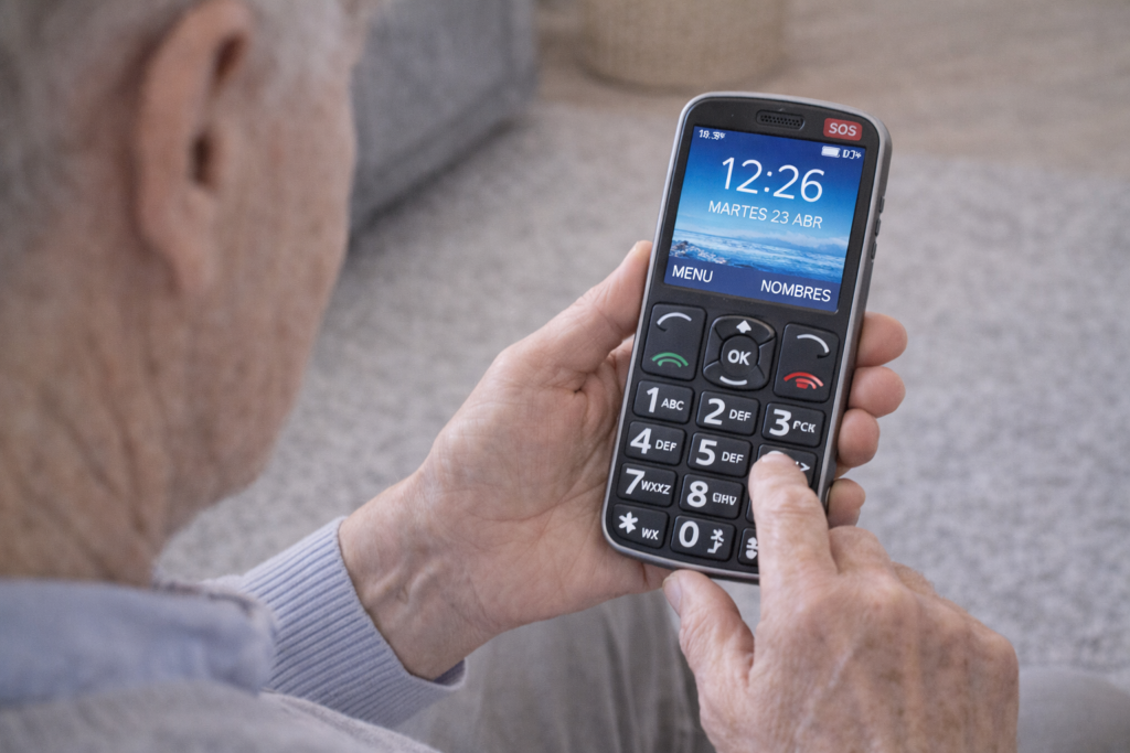 anciano usando uno de los mejores moviles para mayores con teclas grandes.